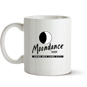 May include: White ceramic mug with a black and white logo that says "Moondance Diner" and "SOHO NEW YORK CITY".