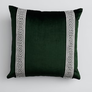 May include: A dark green velvet pillow with white and black Greek key trim.