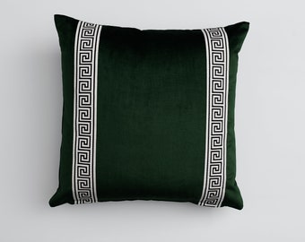 May include: A dark green velvet pillow with white and black Greek key trim.