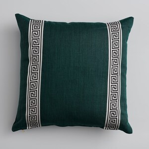 May include: A teal green throw pillow with a white and black geometric pattern on each side.
