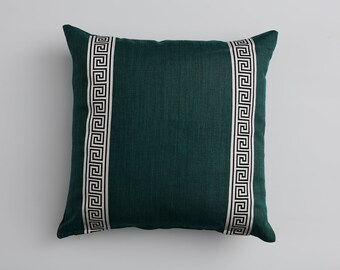 May include: A teal green throw pillow with a white and black geometric pattern on each side.