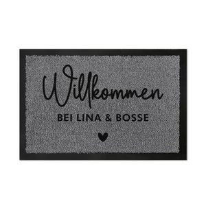 May include: A grey welcome mat with black text that reads "Willkommen bei Lina & Bosse" with a small black heart.