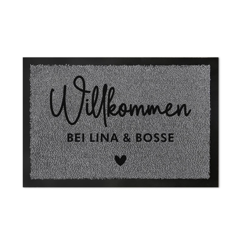 May include: A grey welcome mat with black text that reads "Willkommen bei Lina & Bosse" with a small black heart.
