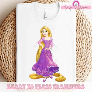 May include: A white t-shirt with a colorful image of Rapunzel from the Disney movie Tangled. The image shows Rapunzel in her purple dress with her long blonde hair. The text "Ready to Press Transfers" is at the bottom of the shirt.