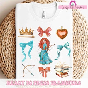 May include: A white t-shirt with a design of a red-haired princess with a bow, a crown, a heart, a bow, an arrow, and a book. The text "Ready to Press Transfers" is at the bottom of the shirt.