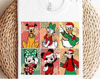 Puede incluir: Camiseta blanca con un diseño navideño colorido con los personajes de dibujos animados Pluto, Daisy Duck, Donald Duck, Minnie Mouse, Mickey Mouse y Goofy. El diseño incluye copos de nieve y el texto "READY TO PRESS TRANSFERS".