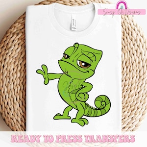 May include: Green cartoon chameleon with a surprised expression, standing on a white t-shirt.  Ready to Press Transfers.