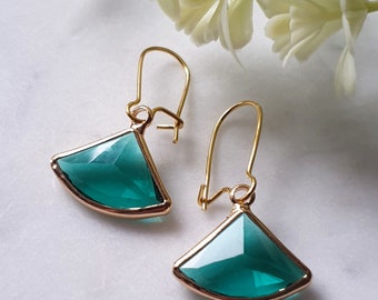 May include: A pair of gold earrings with green gemstone fan-shaped pendants.