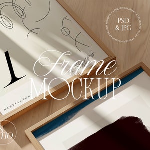 May include: Two wooden framed art prints with abstract designs and the text "Frame Mockup". One print features a large black letter "T" and the word "Manufactum". The other has a blue brushstroke.