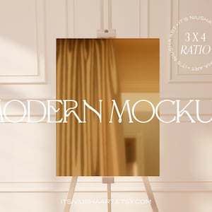 Puede incluir: Una superficie rectangular dorada sobre un caballete de madera, que refleja una cortina y una habitaci&oacute;n. Las palabras "MODERN MOCKUP" se muestran en una fuente elegante, con "3X4 RATIO" y el nombre de la tienda Etsy.
