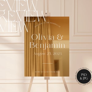 Puede incluir: Un letrero de bienvenida de boda en tono dorado sobre un caballete. El letrero muestra los nombres "Olivia & Benjamin" y la fecha "25 de agosto de 2023". Tambi&eacute;n se ve el texto "Bienvenida a la boda de" y "Nos alegra mucho que est&eacute;s aqu&iacute;".