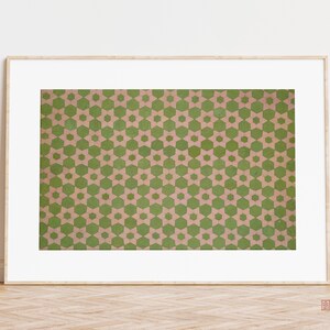 May include: A framed print of a geometric pattern with green and pink stars on a beige background.