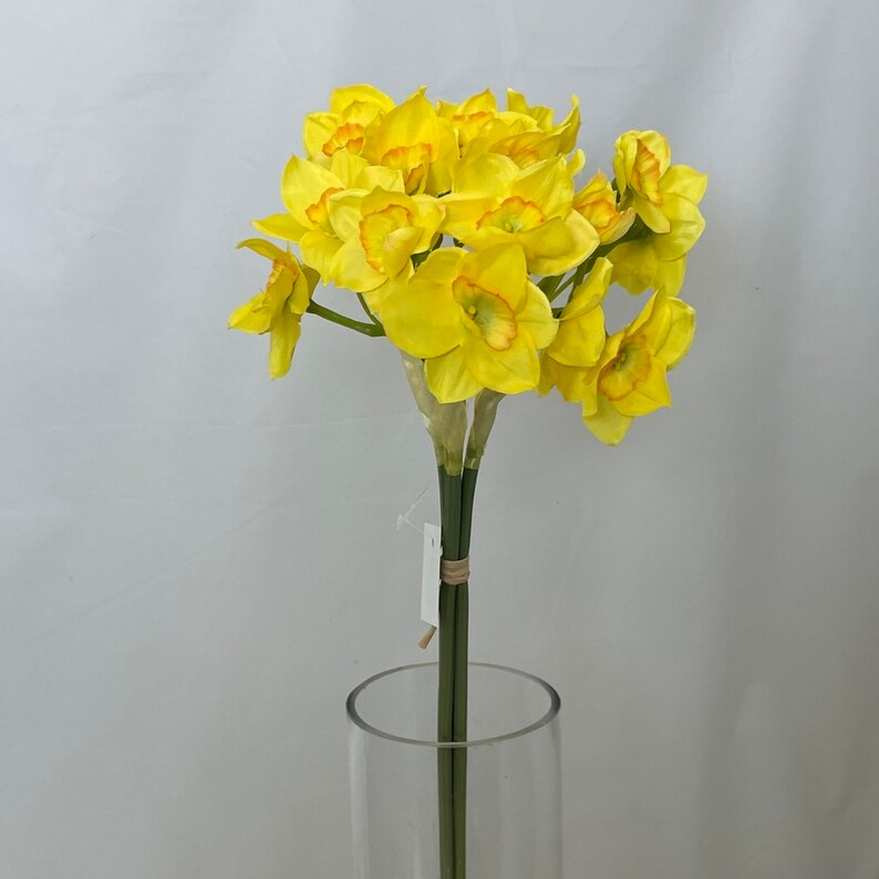May include: A bouquet of yellow daffodils with orange centers. The flowers are arranged in a vase.