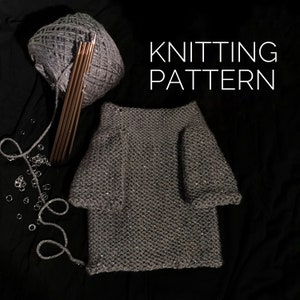 Op de afbeelding: Een grijze gebreide trui met lange mouwen en een ronde hals. De trui is gemaakt met een glinsterend garen en ligt op een zwart oppervlak. De tekst "KNITTING PATTERN" is zichtbaar in de rechterbovenhoek van de afbeelding.