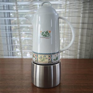 Op de afbeelding: Set van drie keramische mokken met een gespikkelde, matte afwerking. De mokken zijn in crème, lichtgrijs en donkergrijs. Elke mok heeft een eenvoudig, minimalistisch ontwerp.