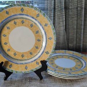 May include: Set of four yellow, blue, and green ceramic dinner plates with a diamond pattern.