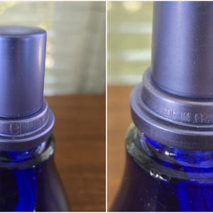 Pu&ograve; includere: Primo piano di una bottiglia di vetro blu con un tappo blu abbinato. La bottiglia ha un tappo blu scuro e un anello attorno al collo con le parole "MADE IN FRANCE" impresse. La bottiglia &egrave; parzialmente visibile.