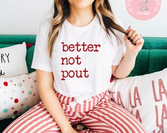 May include: White t-shirt with red text that reads "better not pout". The person wearing the shirt is sitting on a couch wearing red and white striped pants.