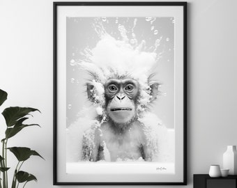 Puede incluir: Una fotografía en blanco y negro de un mono con una expresión de sorpresa, cubierto de burbujas y agua. El mono está sentado en una bañera de agua con burbujas.