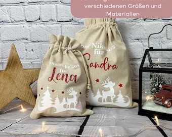 May include: Two beige drawstring gift bags with red text and white deer and tree designs. One bag says "Lena" and the other says "Sandra". The bags are for the holiday season.