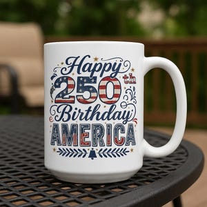 May include: White ceramic mug with the text "Happy 250th Birthday AMERICA" in blue, red, and white. The design incorporates stars and stripes, with a decorative border at the bottom. The mug has a large handle.
