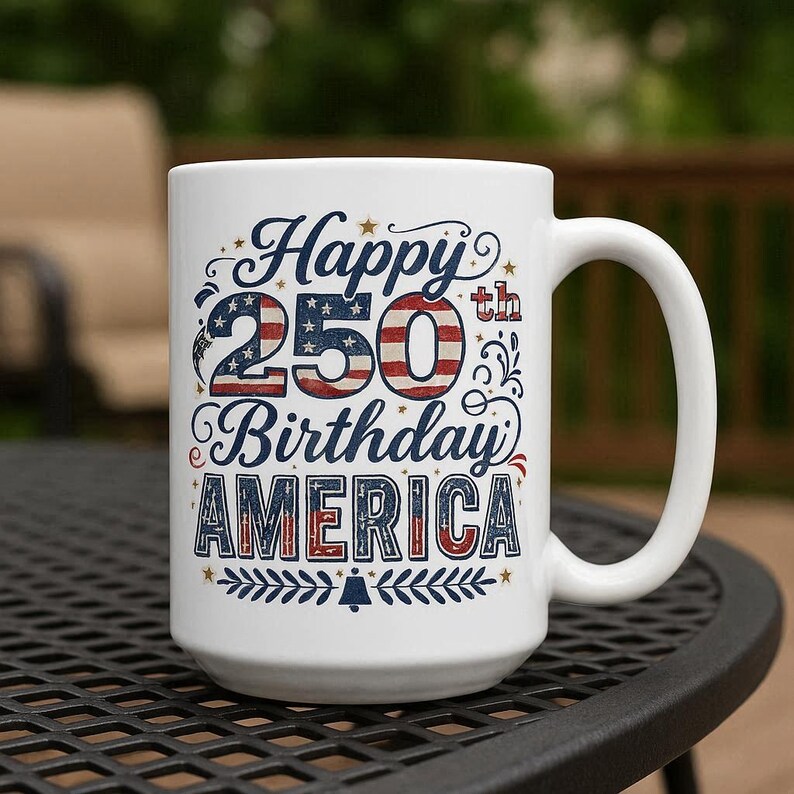 May include: White ceramic mug with the text "Happy 250th Birthday AMERICA" in blue, red, and white. The design incorporates stars and stripes, with a decorative border at the bottom. The mug has a large handle.