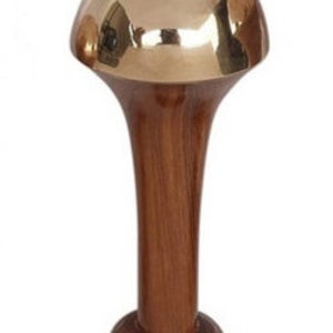 May include: A decorative walking cane with a polished brass mushroom-shaped top and a dark wood handle. The handle flares out from the base to the top, creating a unique, elegant design. The cane's base is a rounded, dark wood.