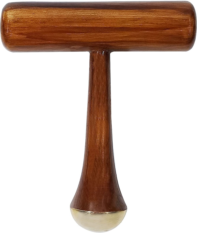 May include: A wooden mallet with a T-shaped design. The handle is a rich brown color, and the striking head is a lighter shade of brown. The bottom of the mallet has a gold-colored, rounded end.