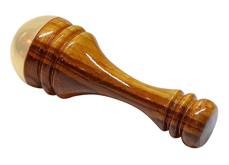 May include: A wooden wax seal stamp with a polished finish. The stamp features a light brown wooden handle and a gold-colored, rounded top. The handle has a layered design with a smooth, glossy appearance.