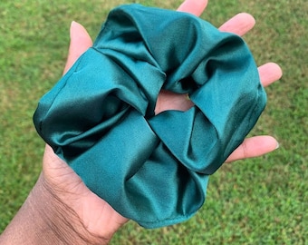 May include: A teal green satin scrunchie for hair.