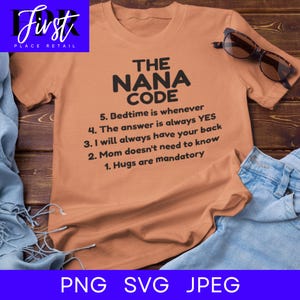 May include: A peach-colored t-shirt with the text "THE NANA CODE" and a list of rules in black font. The shirt is displayed on a wooden surface with a pair of glasses and denim jeans.