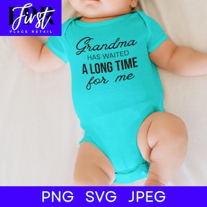 May include: A turquoise baby bodysuit featuring the text "Grandma has waited a long time for me" in black script. The short-sleeved onesie is a simple design, suitable for a newborn or infant.