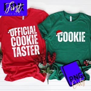 Könnte beinhalten: Zwei Weihnachtsshirts, eines rot und eines grün. Das rote Shirt trägt den weißen Schriftzug "OFFICIAL COOKIE TASTER", das grüne Shirt "COOKIE" mit einem Weihnachtsmütze. Festliche Weihnachtsbekleidung.