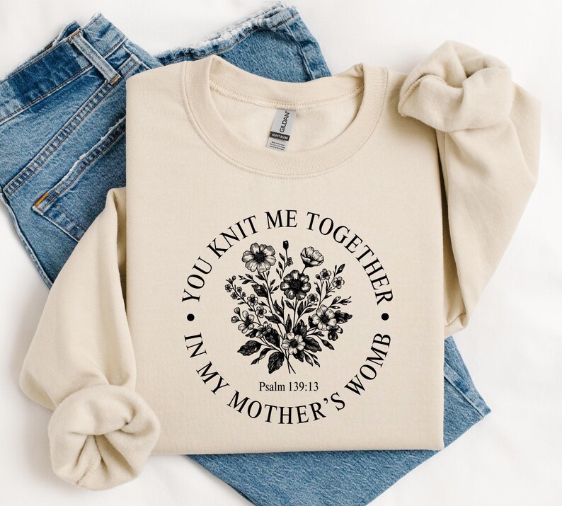 May include: A beige sweatshirt with a black floral design and the text "You knit me together in my mother's womb. Psalm 139:13"