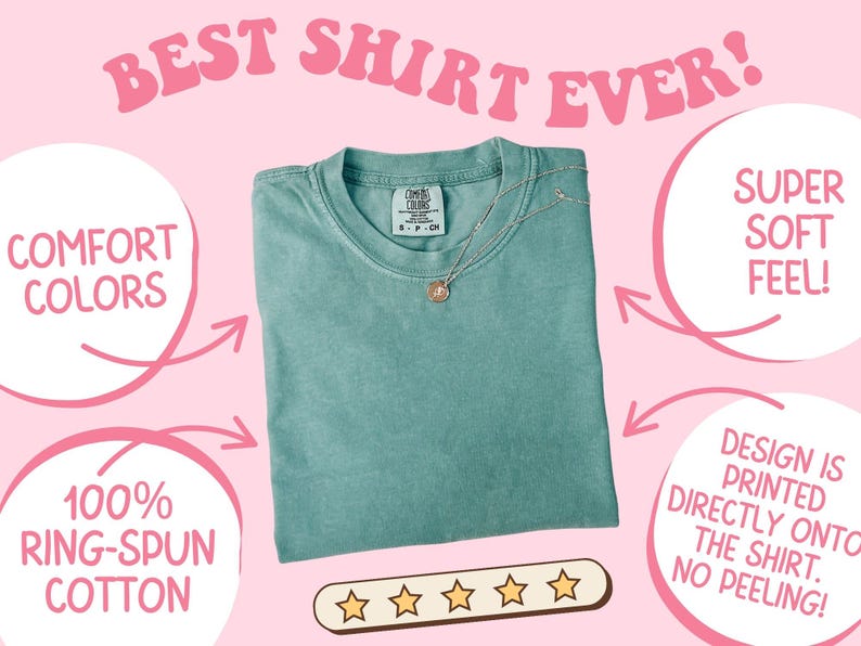 Puede incluir: Una camiseta de color verde azulado con el texto "BEST SHIRT EVER!" en rosa. La camiseta est&aacute; hecha de 100% algod&oacute;n hilado en anillo y tiene un tacto s&uacute;per suave. Un collar de oro con un colgante descansa sobre la camiseta. El dise&ntilde;o est&aacute; impreso directamente en la camiseta.