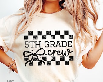 Puede incluir: Una camiseta blanca con texto negro que dice "5th Grade Crew" con un patrón de cuadros blanco y negro y un lazo negro con brillo sobre el texto.