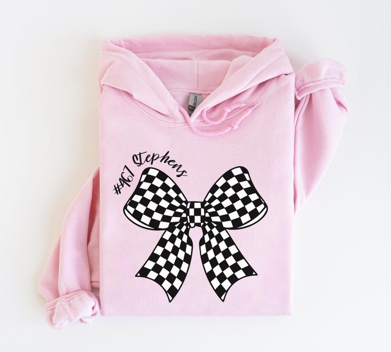 May include: Pink hoodie with a black and white checkered bow and the text "Stephens #467" printed on the front.