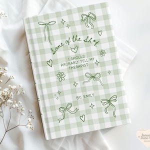May include: A hardcover journal with a green and white gingham pattern. The cover features the text "Some of the sh*t I should probably tell my therapist" with decorative bows, hearts, and stars. The author's name, Emily, is also printed on the cover.