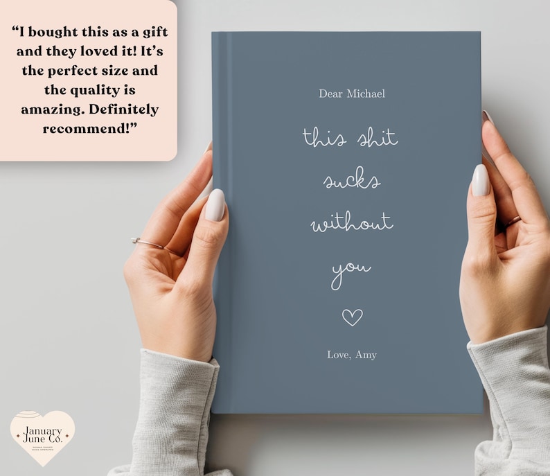 Peut inclure: Un journal bleu avec le texte "this shit sucks without you" et un symbole de c&oelig;ur. Le journal est tenu par une personne. Le texte "Dear Michael" et "Love, Amy" sont &eacute;galement visibles.