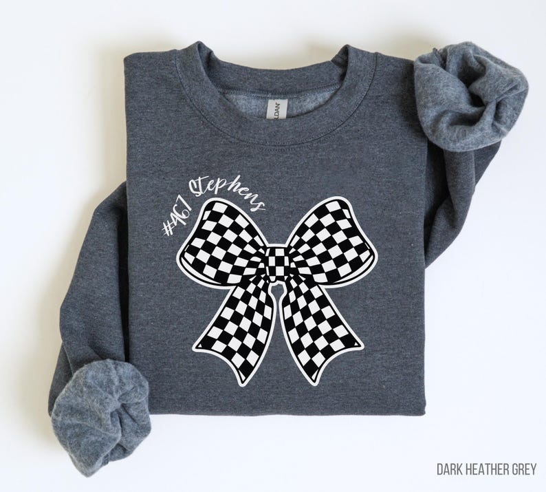 May include: Dark heather grey sweatshirt with a black and white checkered bow and the text "#467 Stephens" printed on the front.