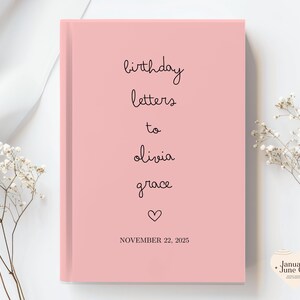 May include: A pink journal with the words "birthday letters to olivia grace" in black script. A heart symbol is below the names, and the date "NOVEMBER 22, 2025" is printed at the bottom. The journal is a hardcover book.