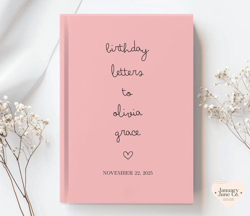 May include: A pink journal with the words "birthday letters to olivia grace" in black script. A heart symbol is below the names, and the date "NOVEMBER 22, 2025" is printed at the bottom. The journal is a hardcover book.