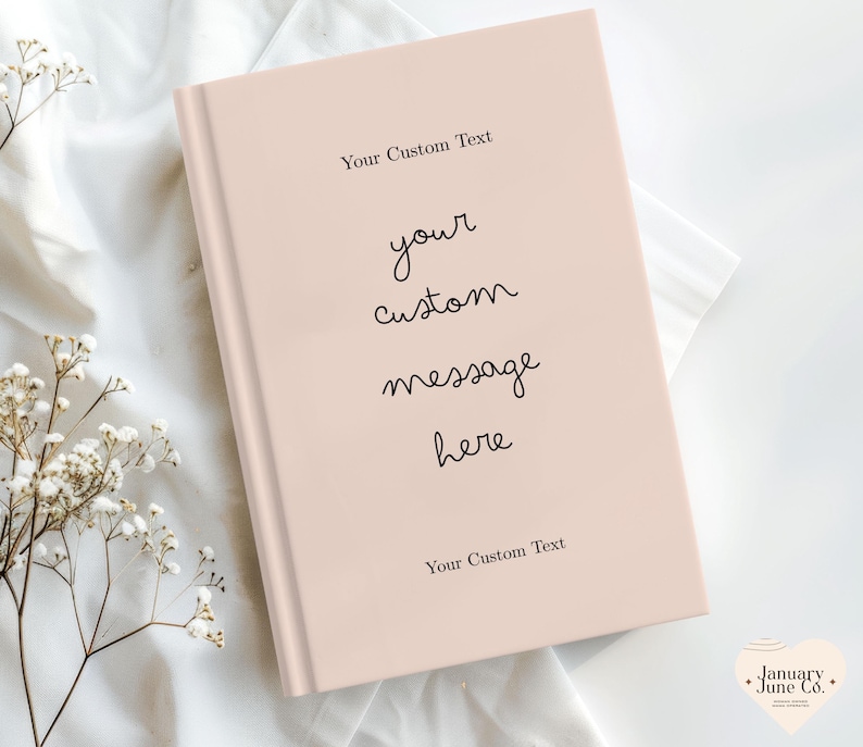 Puede incluir: Un diario de color rosa p&aacute;lido con el texto "Your Custom Text" en la parte superior e inferior. Las palabras "your custom message here" est&aacute;n escritas en cursiva en la portada. El diario est&aacute; sobre una superficie blanca.