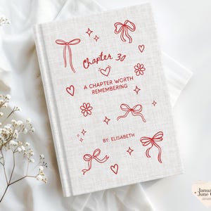 May include: A hardcover book with a light beige linen cover. Red line art includes bows, hearts, flowers, and stars. The text reads "Chapter 30, A Chapter Worth Remembering, By: Elisabeth."