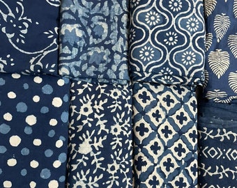 Puede incluir: Una colección de ocho muestras de tela con varios patrones en azul índigo y blanco. Los patrones incluyen diseños florales, geométricos y de hojas.