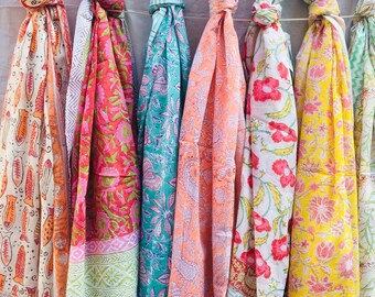May include: A collection of colorful scarves with floral and geometric patterns. The scarves are made of cotton and are perfect for adding a touch of color to any outfit.