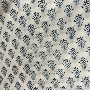 K&ouml;nnte beinhalten: Ein wei&szlig;er Stoff mit einem sich wiederholenden Muster aus kleinen, dunkelblauen Blumenmotiven. Jedes Motiv besteht aus einem zentralen Stiel mit symmetrischen Bl&auml;ttern und einer f&uuml;nfbl&auml;ttrigen Bl&uuml;te an der Spitze, die gleichm&auml;&szlig;ig angeordnet sind.