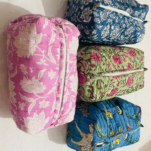 Puede incluir: Cuatro bolsas acolchadas con cremallera con diseños florales y de animales. Las bolsas son de color rosa, verde, azul y azul con detalles blancos.