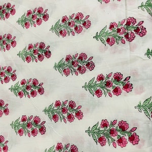 May include: White fabric with a repeating pattern of pink and green floral sprigs. The fabric has a subtle texture.