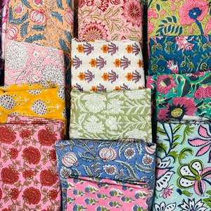 Puede incluir: Una colecci&oacute;n de cuadrados de tela coloridos con patrones florales. Las telas est&aacute;n dispuestas en una cuadr&iacute;cula y presentan una variedad de colores, incluyendo rosa, azul, verde, amarillo y blanco.